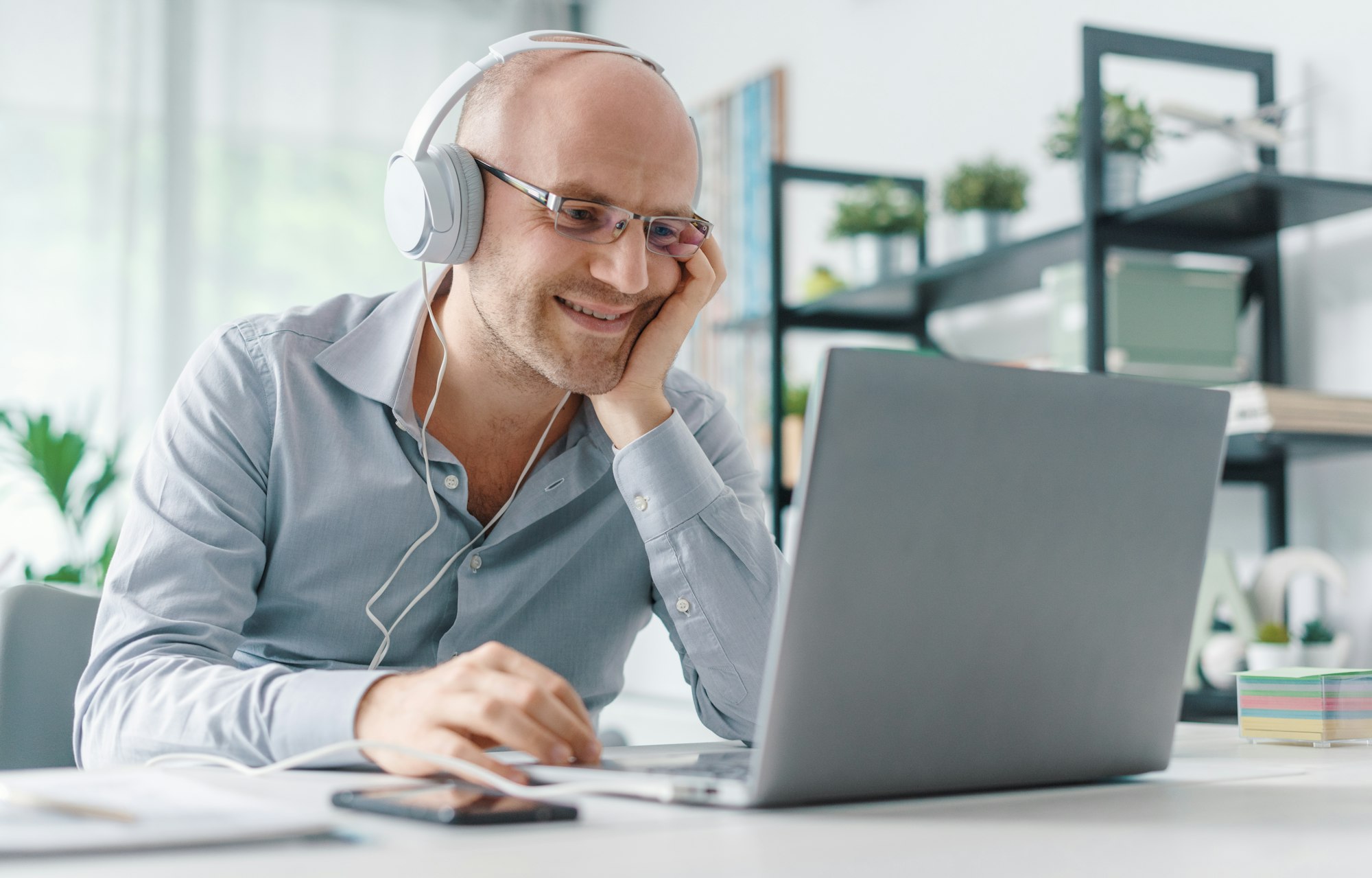Happy remote worker connecting with his laptop